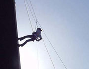 Photo of someone abseiling down Kingston University's tower block in 2002